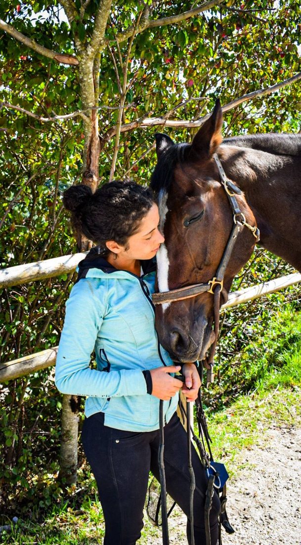 Célia Le Fur, front contre la tête de son cheval bai